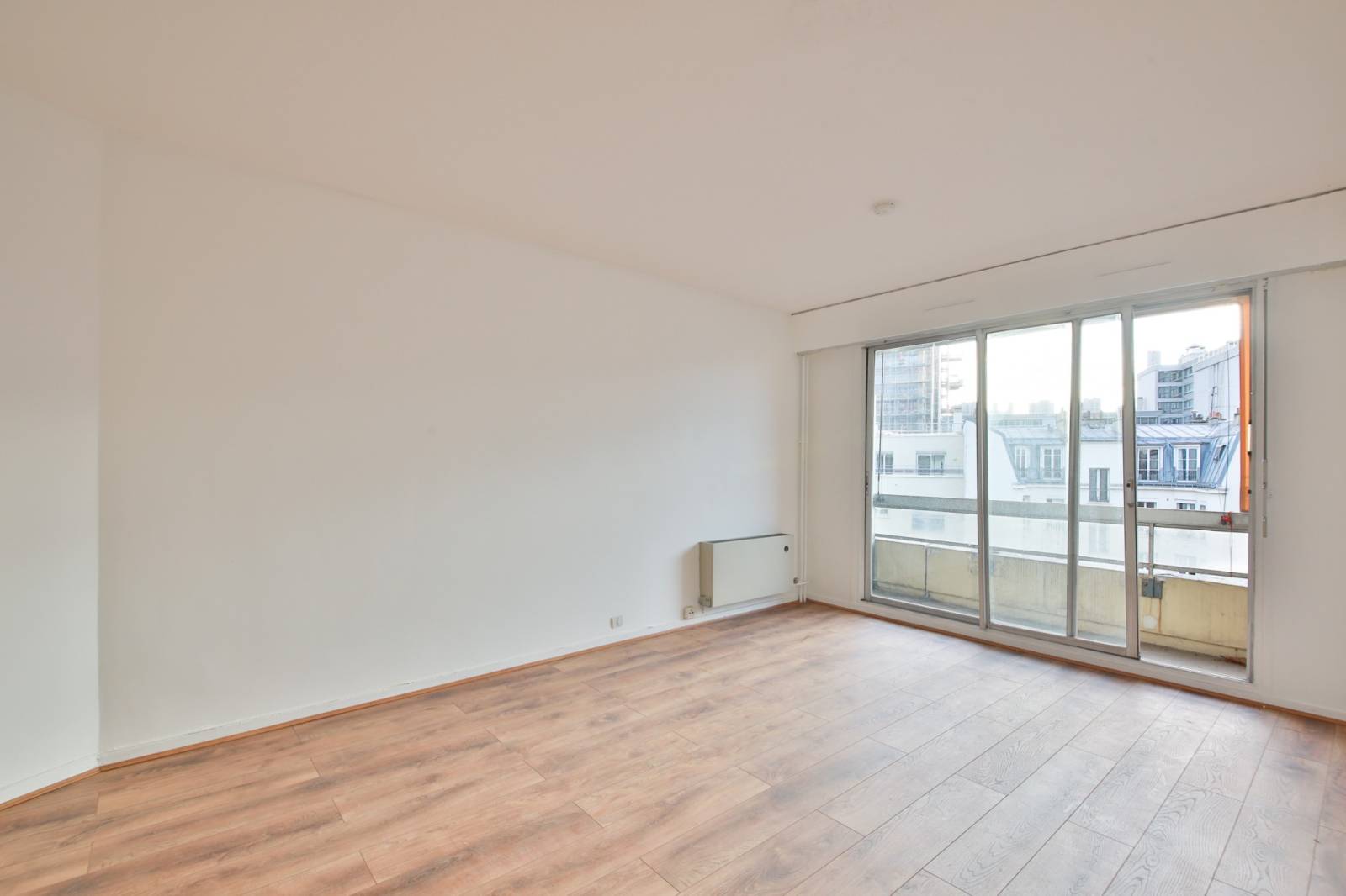 Séjour donnant sur un agréable balcon en étage élevé dans un appartement 2 pièces situé dans le 15ème arrondissement 