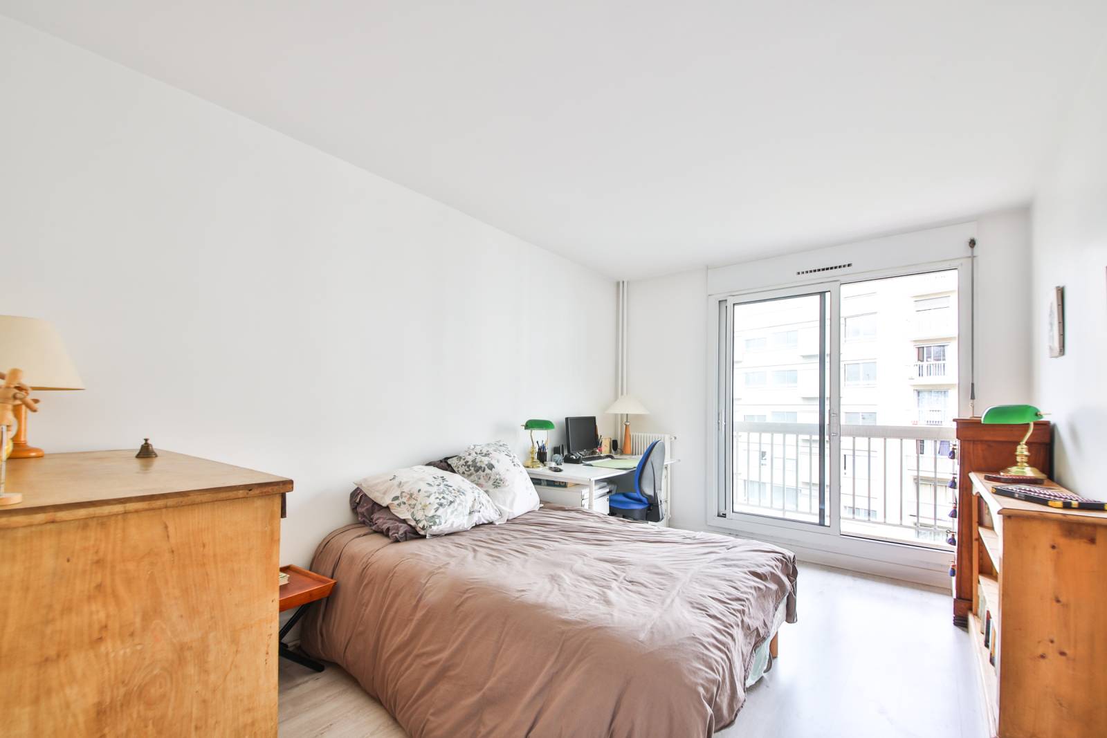 Une chambre parentale donnant sur un balcon lumineux et pourvu de nombreux rangement et très lumineuse