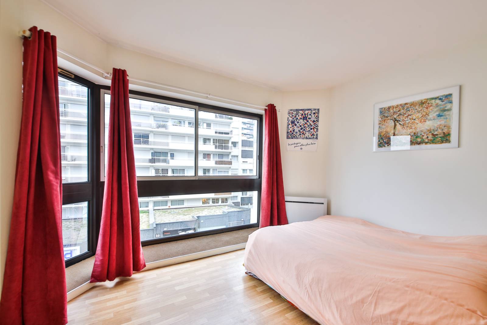 chambre avec baie vitrée très lumineuse pourvu de rangement.