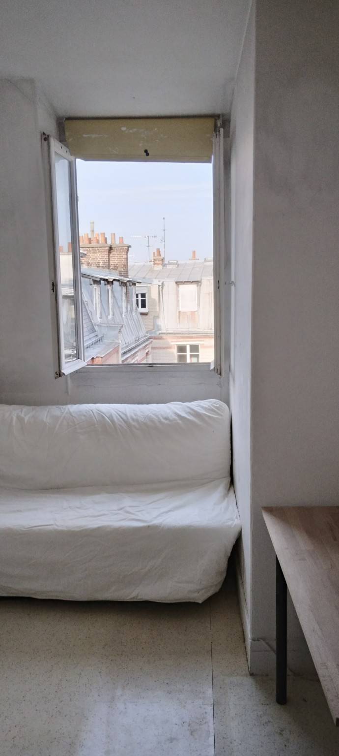 Espace nuit de la chambre de service de 7,38m² à Paris 7ème, agencé de manière fonctionnelle au 7ème étage d'un immeuble ancien de bon standing