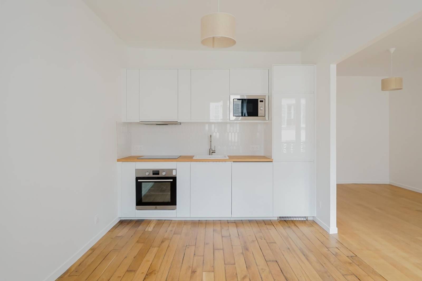 Cuisine ouverte moderne et équipée dans un appartement rénové dans Paris 14ème