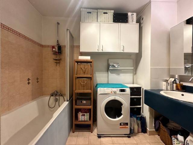 Salle de bains aménagée et équipée avec un coin buanderie