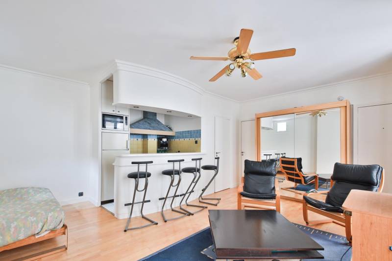 Cuisine équipée et ouverte sur séjour dans un studio moderne et fonctionnel à Paris 14ème proche des commerces et des transports