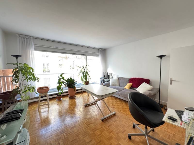 Séjour ouvrable sur une cuisine et donnant accès à un balcon d'un appartement à vendre avenue de Suffren