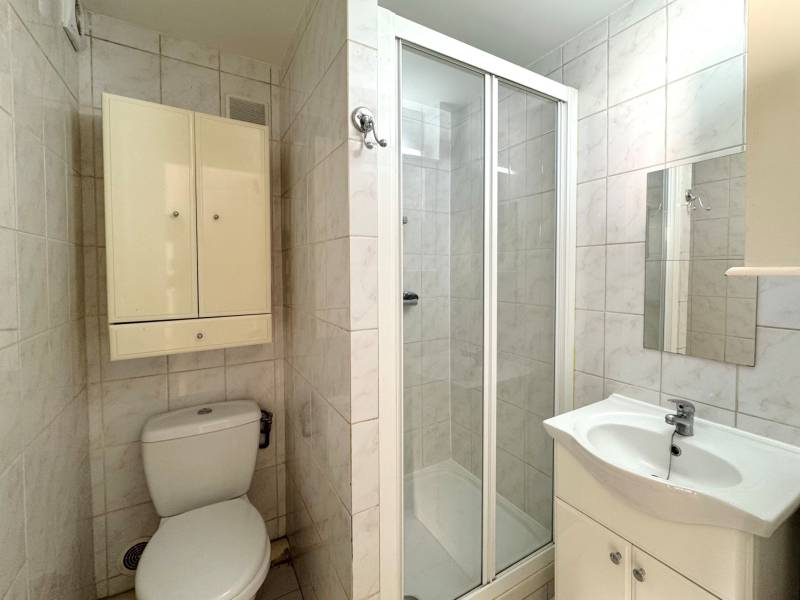 Salle d’eau avec douche, WC et meuble vasque, en bon état général