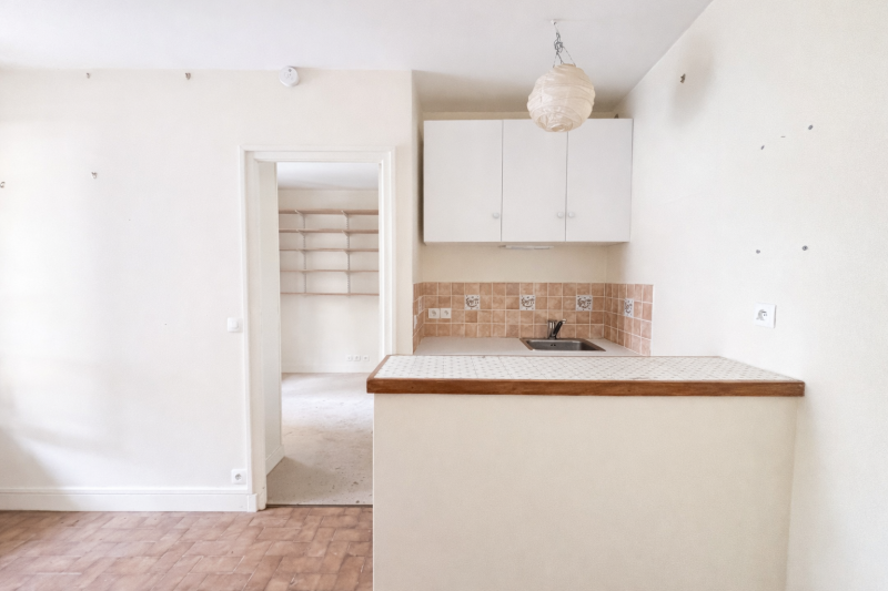 Cuisine ouverte sur le séjour dans un appartement 2 pièces à Paris 14ème offrant un espace de vie fonctionnel 