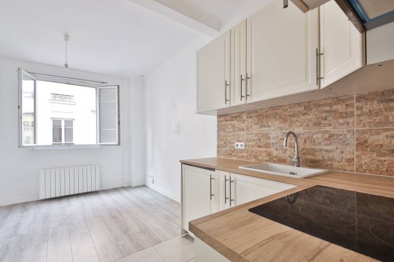 Coin cuisine aménagé avec four et plaque dans un studio de 18m² à Paris 14ème 